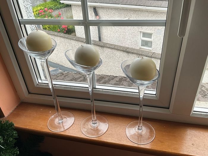 Set of 3 clear glass stemmed candle holders with ivory candles