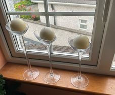 Set of 3 clear glass stemmed candle holders with ivory candles