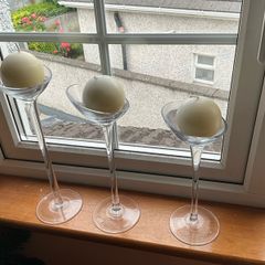Set of 3 clear glass stemmed candle holders with ivory candles