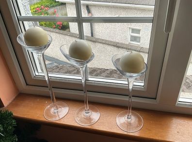 Set of 3 clear glass stemmed candle holders with ivory candles