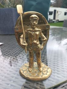 Heavy solid brass sailor with boat on back, 1979, D18 post 10e