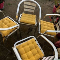 Set of matching patio chairs and four yellow seat pads
