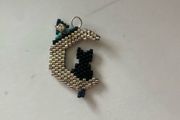 beaded black cat sitting on a crescent moon
