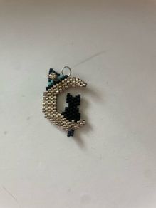 beaded black cat sitting on a crescent moon