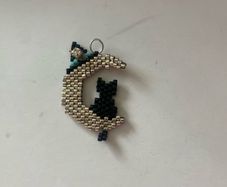 beaded black cat sitting on a crescent moon