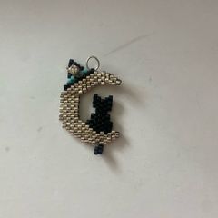beaded black cat sitting on a crescent moon