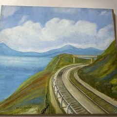 picture This piece depicts a railway line sweeping around a coastal bay beneath a footbridge and hillsides, signed Brian Davies in the lower left corner.