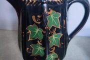 Victorian pottery pitcher. Gloss black glazed pitcher with ivy leaf design in green