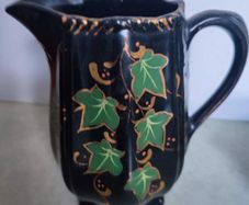 Victorian pottery pitcher. Gloss black glazed pitcher with ivy leaf design in green