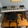RockJam Electronic Keyboard Piano set up on a sturdy, matching heavy-duty Z-frame stand and an adjustable padded X-frame RockJam Keyboard Bench resting on a wooden surface. Image 7