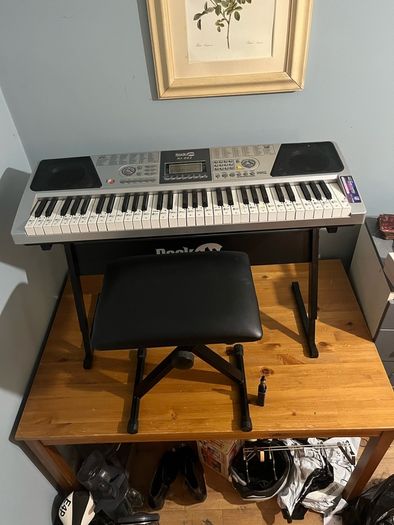 RockJam Electronic Keyboard Piano set up on a sturdy, matching heavy-duty Z-frame stand and an adjustable padded X-frame RockJam Keyboard Bench resting on a wooden surface.