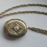 A large medallion featuring religious symbols, suspended from a long chain. Image 3