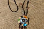 This is a bohemian-style long necklace featuring a resin pendant and beaded tassels.