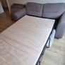 Grey two-seater sofa bed with matching storage footstool Image 4