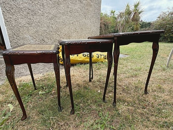 A vintage glass-protected, gold-tooled, leather top nest of tables