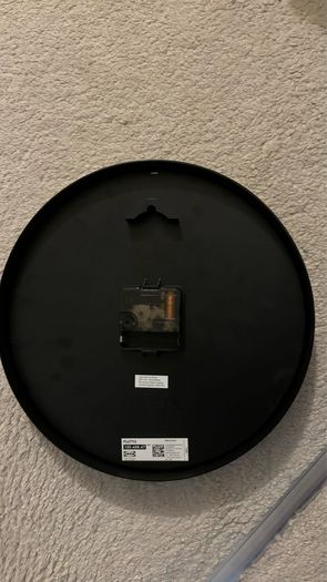 2 wooden chairs and a wall clock