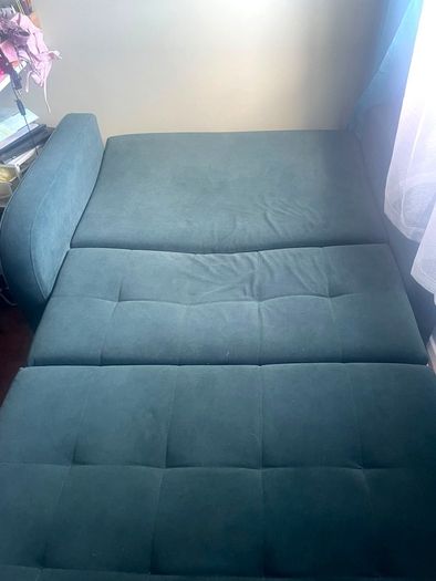 Grey fabric sofa bed with large storage compartment.