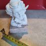 A small clay figure of an white angel on a marble plaint . Image 6