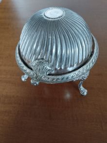 A vintage silver-plated butter dish or caviar bowl with a three-legged lid.