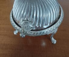 A vintage silver-plated butter dish or caviar bowl with a three-legged lid.