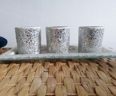 This mosaic glass set features three silver-crushed glass votive holders on a matching mirrored tray