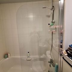 Glass shower screen for a bath