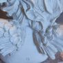 A small clay figure of an white angel on a marble plaint . Image 5