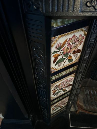 Victorian style cast iron fireplace with floral tiles