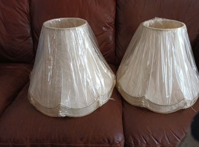 A pair of cream coloured lamp shades still in wrapping