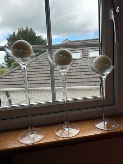 Set of 3 clear glass stemmed candle holders with ivory candles