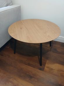 Round wooden coffee table with black legs