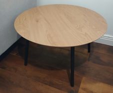 Round wooden coffee table with black legs