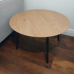 Round wooden coffee table with black legs