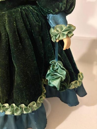 Vintage porcelain doll in green velvet dress