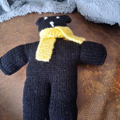 Hand knitted black teddy bear with yellow scarf