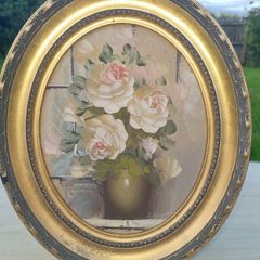 Oval oil painting depicting a still life with flowers,