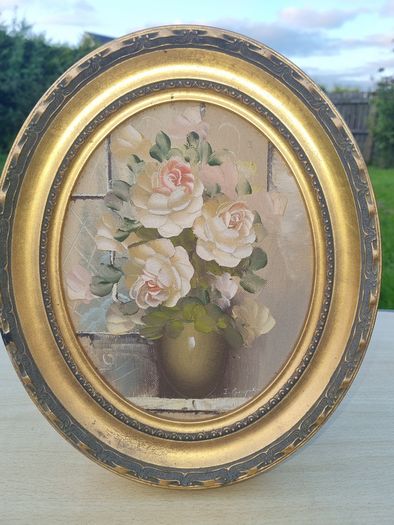 Oval oil painting depicting a still life with flowers,