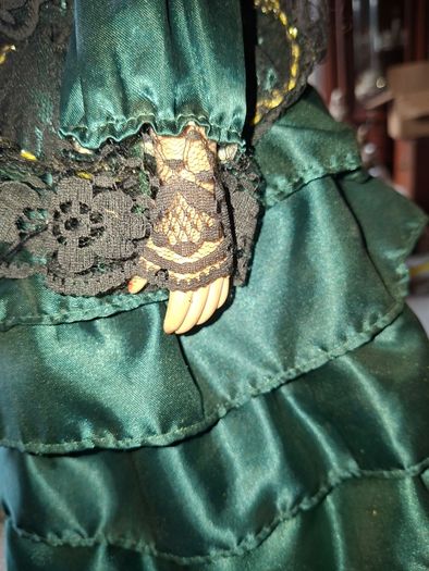 Vintage Large Victorian-style collectible Porcelain Doll featuring curly reddish-brown hair and a multi-layered emerald green satin and lace dress