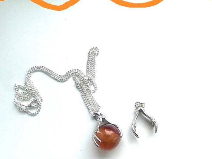 Silver tone necklace with unique hand-clasp pendant