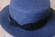 Blue woven straw boater hat with black ribbon bow, lightweight and excellent condition.