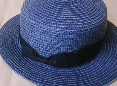 Blue woven straw boater hat with black ribbon bow, lightweight and excellent condition.