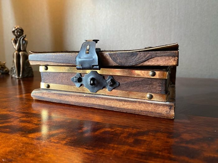 antique A wooden box in the form of a book, having brass escutcheon and black metal hinges. 18 x 15cm.