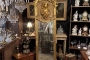 Tall gilt mirror with decorative top