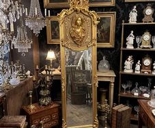 Tall gilt mirror with decorative top