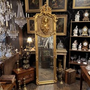Tall gilt mirror with decorative top