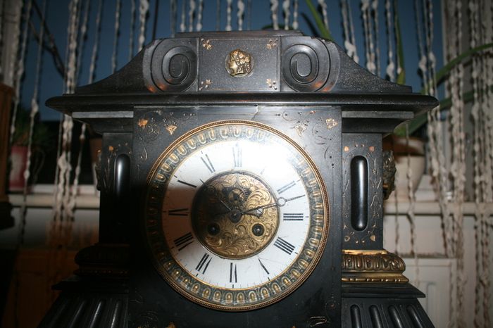 Victorian French Black Slate Mantle Clock (Very large and heavy) with bronze ornamentation Oversized. Open escarpment slate plate Roman numerals. Circa 1890s. Accented with Trojan head. Flanked by two Hellenistic ladies heads on sides. Rose cartouche mask