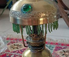 Antique petit brass oil lamp with green beaded garland