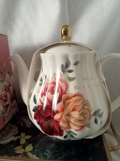 Gift set of a teapot, mug, spoon and coaster.