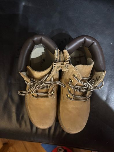 pair of tan/wheat leather boots with a padded dark brown collar.
