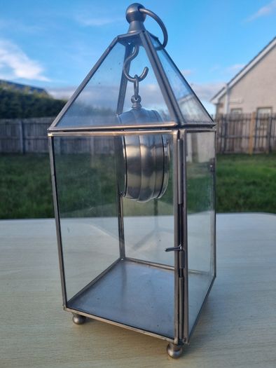 Table clock in a glass lantern.
